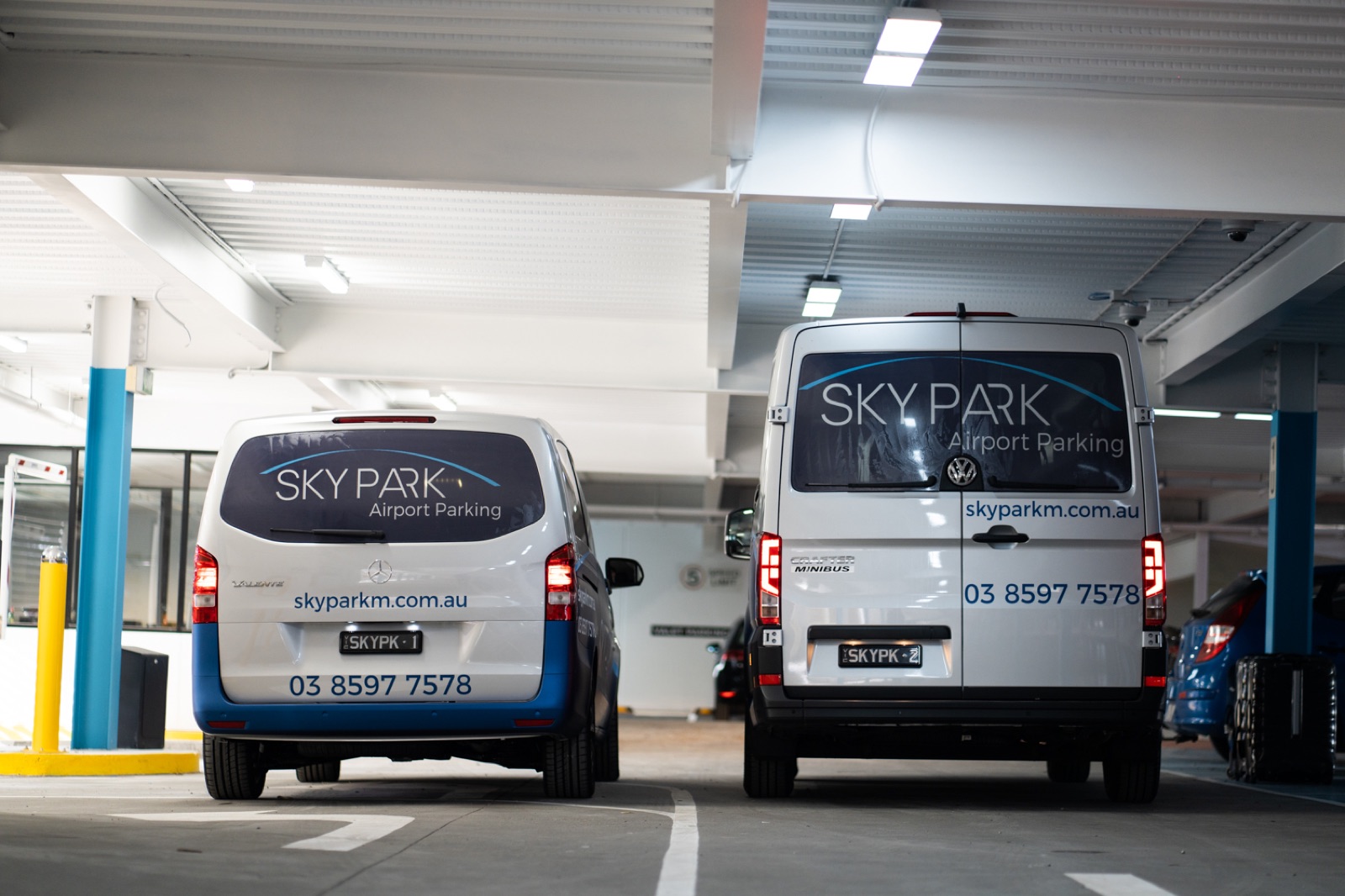 Two Skypark shuttle vans in branded livery